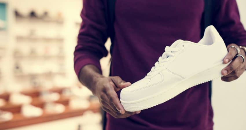 African man holding a white sneaker